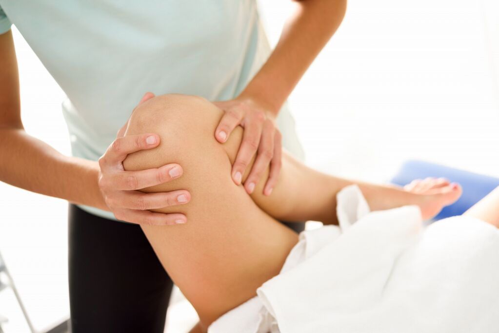 The specialist performs the therapeutic massage with osteoarthritis of the knee